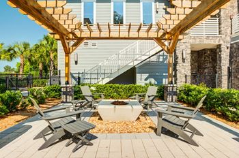 a patio with tables and chairs under a wooden pergola at Century Town Center, Florida